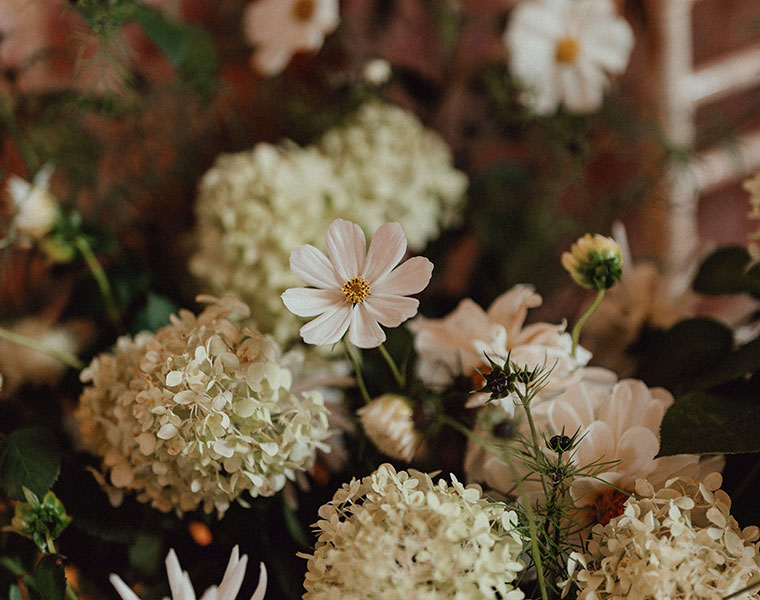 Wedding flowers with blush roses, cream blooms, and textured greenery