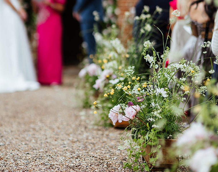 Wedding aisle decorated with meadow-style flowers along the path