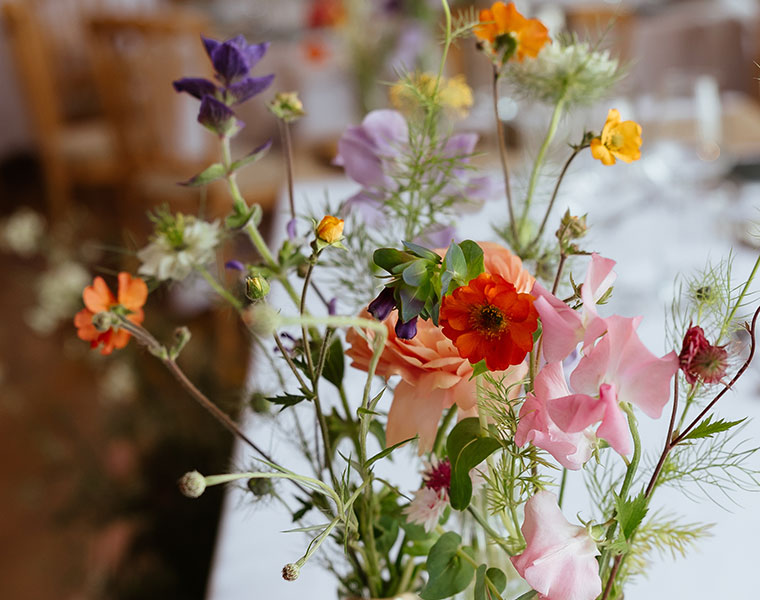 Colourful wildflower arrangement in glass vases for a wedding table